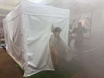 写真：煙避難体験　煙の中では壁を頼りに避難を！
