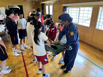 毛布でけが人を運ぶ訓練の写真