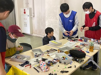 3ミニ四駆コーナーの様子1中学生が、熱心に作り方を教えます