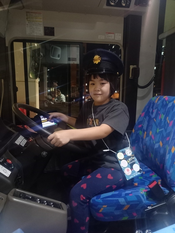 バスの運転席に座る女の子の写真