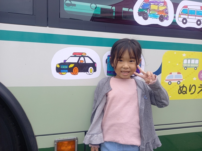 ぬりえと記念撮影する子どもの写真